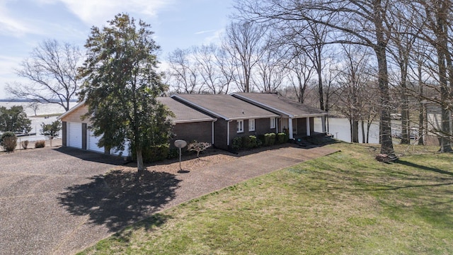 ranch-style home featuring driveway, a garage, and a front lawn