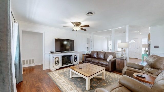 living area with visible vents, wood finished floors, and ceiling fan