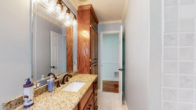bathroom with tile patterned flooring, vanity, ornamental molding, baseboards, and visible vents