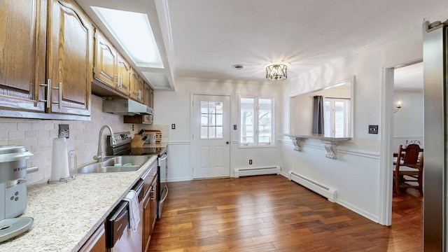 kitchen featuring dishwasher, dark wood-style flooring, a sink, and a baseboard heating unit