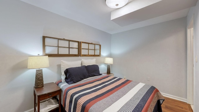 bedroom featuring baseboards and wood finished floors