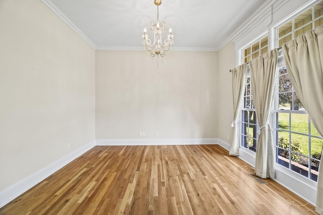 unfurnished dining area featuring a chandelier, baseboards, crown molding, and wood finished floors