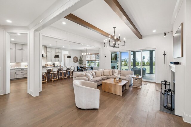 living room featuring beamed ceiling, a notable chandelier, wood finished floors, and recessed lighting