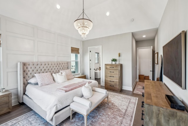 bedroom with lofted ceiling, recessed lighting, a chandelier, a decorative wall, and wood finished floors
