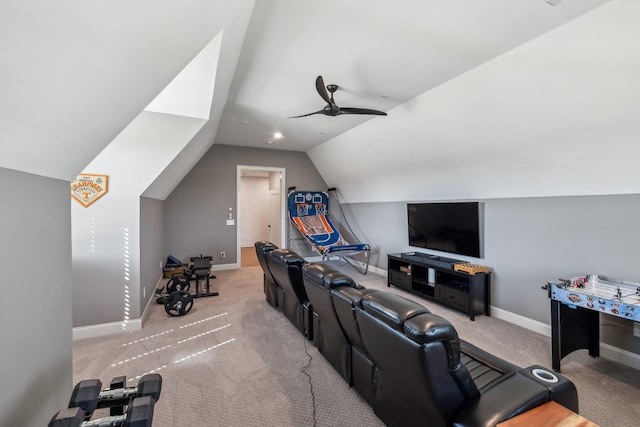 carpeted home theater featuring baseboards, vaulted ceiling, and a ceiling fan