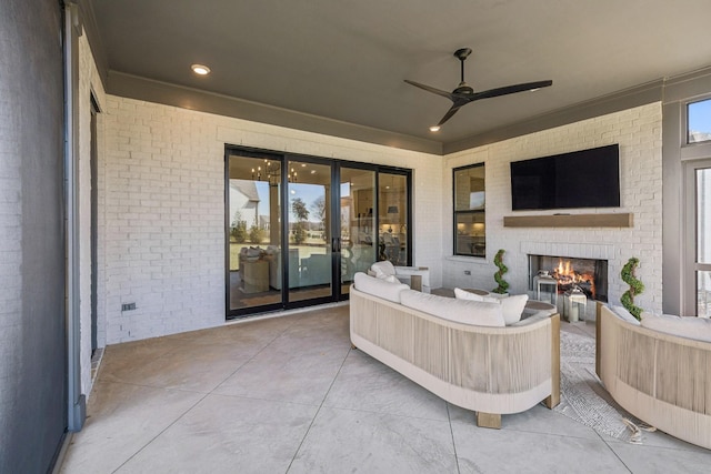 view of patio with ceiling fan and an outdoor living space with a fireplace