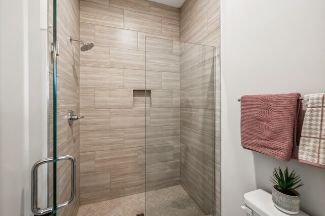 bathroom with a shower stall and toilet