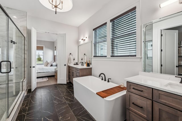 bathroom with ensuite bathroom, marble finish floor, a sink, a stall shower, and a freestanding bath