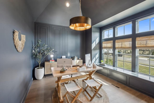 dining room featuring baseboards, visible vents, and wood finished floors