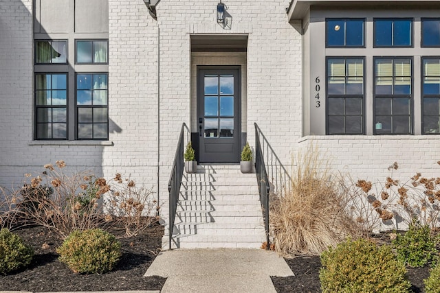 view of exterior entry featuring brick siding