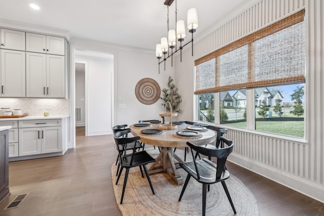 dining space with baseboards, visible vents, wood finished floors, and recessed lighting