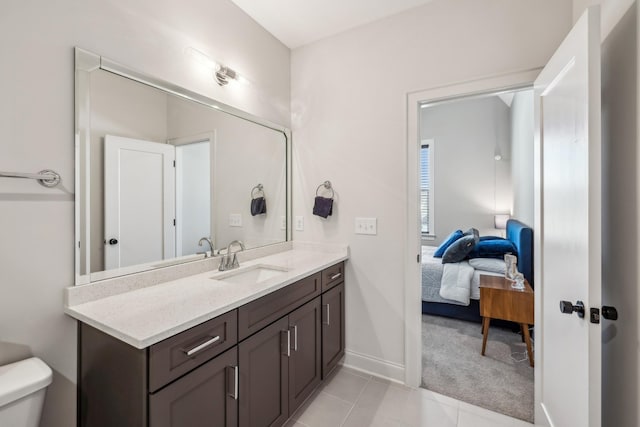 ensuite bathroom with ensuite bathroom, baseboards, toilet, tile patterned floors, and vanity