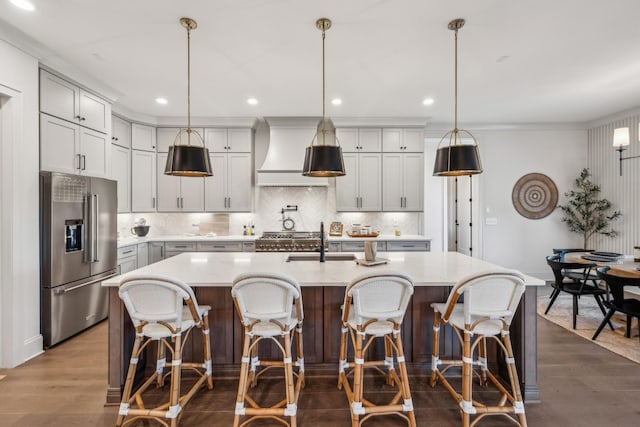 kitchen featuring light countertops, premium range hood, high quality fridge, a sink, and dark wood-style floors