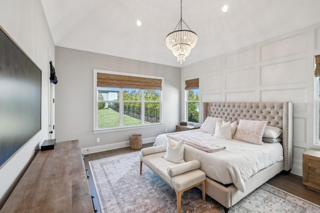 bedroom featuring a decorative wall, a notable chandelier, and wood finished floors