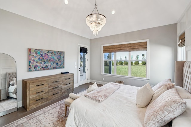 bedroom with an inviting chandelier, dark wood-type flooring, access to outside, and baseboards