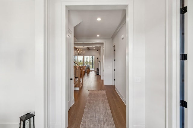 corridor with crown molding, an upstairs landing, a chandelier, wood finished floors, and recessed lighting