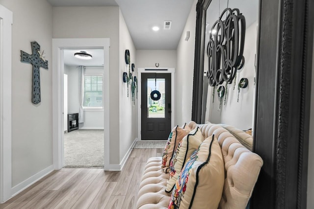 entryway with baseboards, light wood-style floors, and visible vents