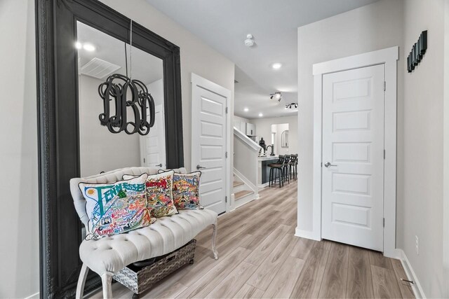 interior space featuring a notable chandelier, stairway, light wood-type flooring, baseboards, and recessed lighting
