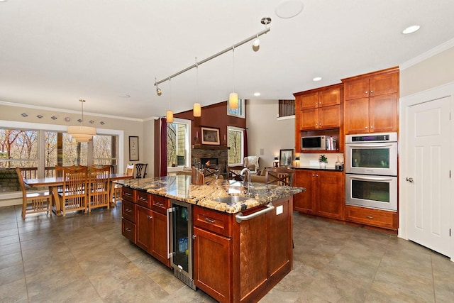 1748 Riverhaven Dr, Adams, TN 37010 - kitchen featuring a sink, appliances with stainless steel finishes, a center island with sink, beverage cooler, and ornamental molding