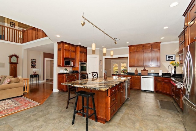 1748 Riverhaven Dr, Adams, TN 37010 - kitchen with an island with sink, a sink, a kitchen bar, appliances with stainless steel finishes, and dark stone counters