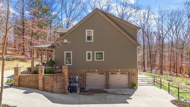 1748 Riverhaven Dr, Adams, TN 37010 - view of home's exterior featuring cooling unit, fence, driveway, brick siding, and a garage
