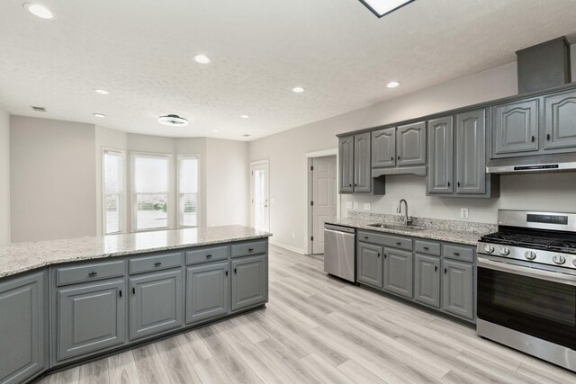 102 Highland Rdg, Hendersonville, TN 37075 - kitchen with gray cabinets, stainless steel appliances, under cabinet range hood, a sink, and light wood finished floors