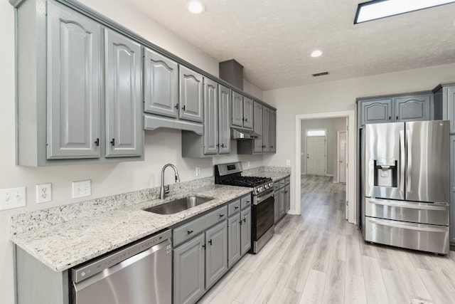 102 Highland Rdg, Hendersonville, TN 37075 - kitchen with stainless steel appliances, under cabinet range hood, a sink, light wood-style floors, and gray cabinets