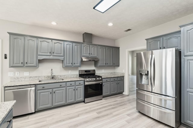 102 Highland Rdg, Hendersonville, TN 37075 - kitchen featuring gray cabinets, under cabinet range hood, a sink, light wood-style floors, and appliances with stainless steel finishes