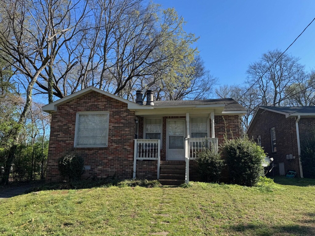 2502C Sharondale Dr, Nashville, TN 37215 - bungalow-style home featuring brick siding, a chimney, a front lawn, and a porch