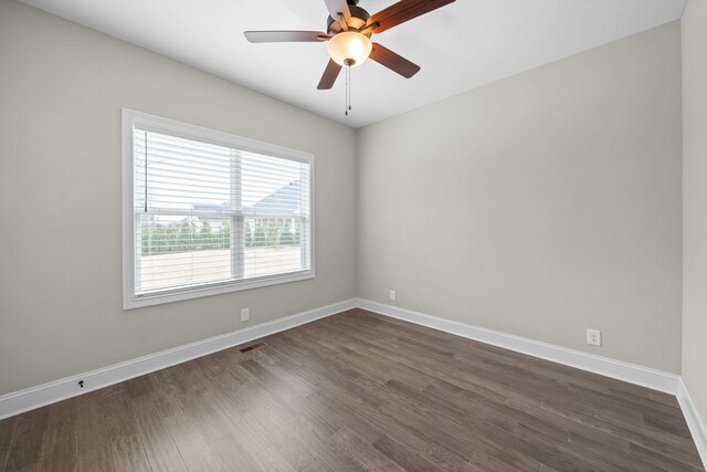spare room with visible vents, baseboards, ceiling fan, and dark wood finished floors