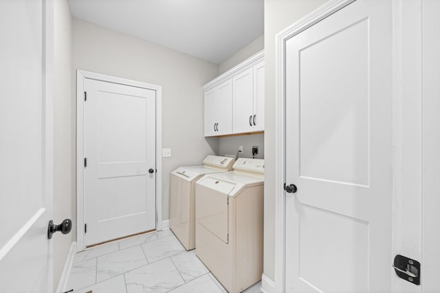washroom with marble finish floor, washing machine and dryer, and cabinet space