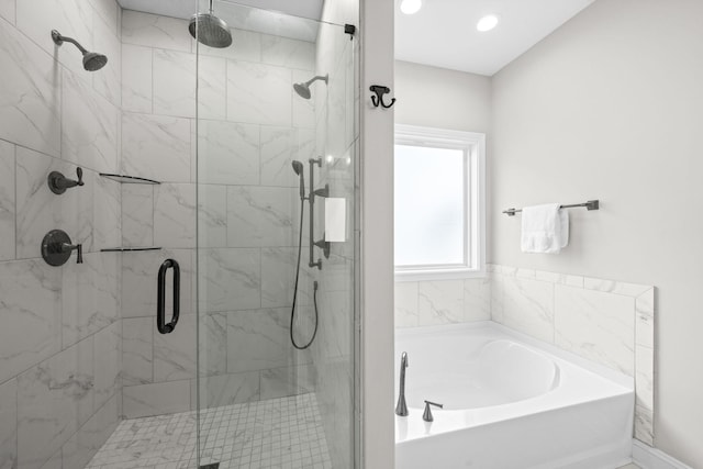 bathroom with a stall shower and a garden tub