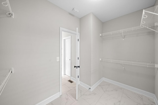 spacious closet with marble finish floor and visible vents
