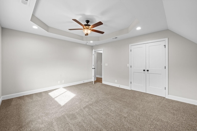 unfurnished bedroom with baseboards, recessed lighting, carpet, and a raised ceiling