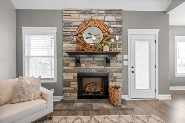 living room featuring baseboards, a fireplace, and wood finished floors