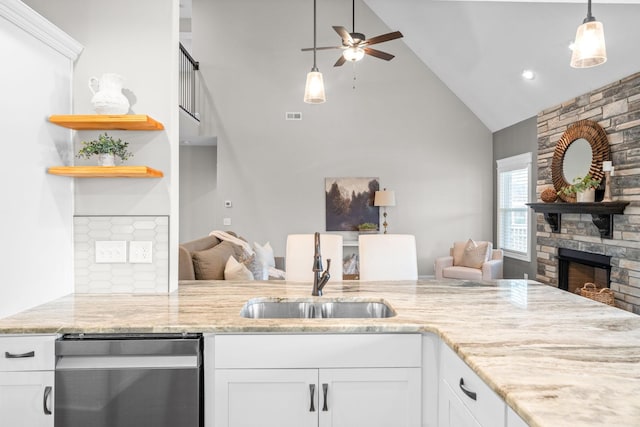 kitchen with open floor plan, a fireplace, a sink, and dishwasher