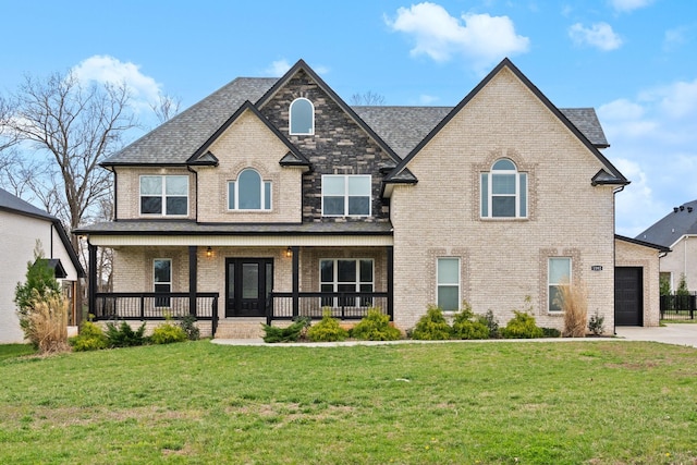 view of front of home featuring a front yard, a porch, brick siding, and concrete driveway