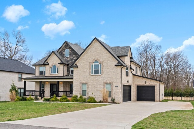 view of front of home with concrete driveway, fence, a front lawn, covered porch, and brick siding