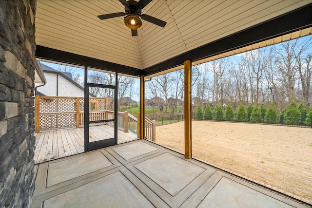 unfurnished sunroom featuring ceiling fan