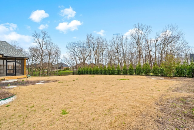 view of yard with a sunroom and fence