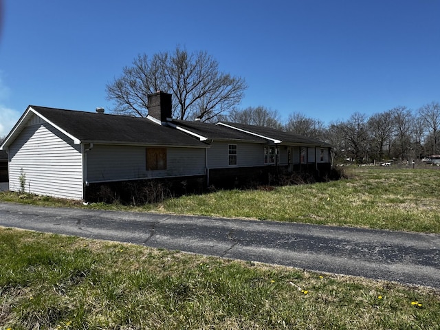 view of property exterior featuring a lawn and a chimney