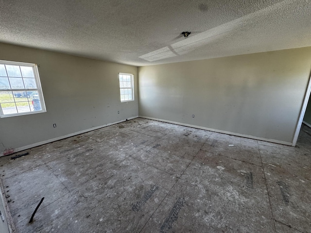 unfurnished room featuring baseboards, visible vents, and a textured ceiling