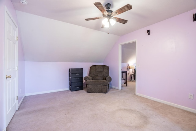 sitting room with a ceiling fan, carpet, baseboards, and lofted ceiling