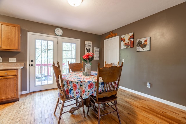 dining room with baseboards and light wood-type flooring