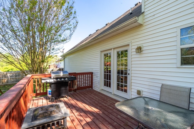 wooden deck with a grill and fence
