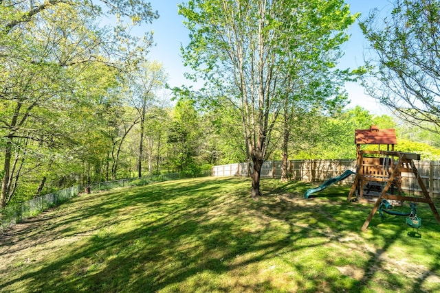 view of yard featuring a fenced backyard and a playground