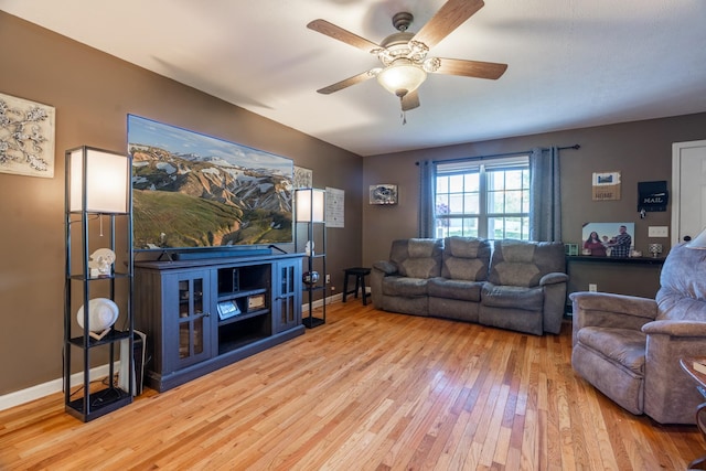 living room with baseboards, ceiling fan, and wood-type flooring