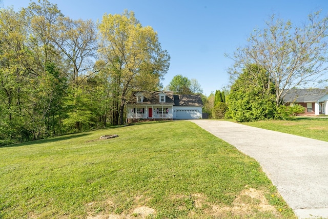 view of front of property with a front yard, concrete driveway, and a garage