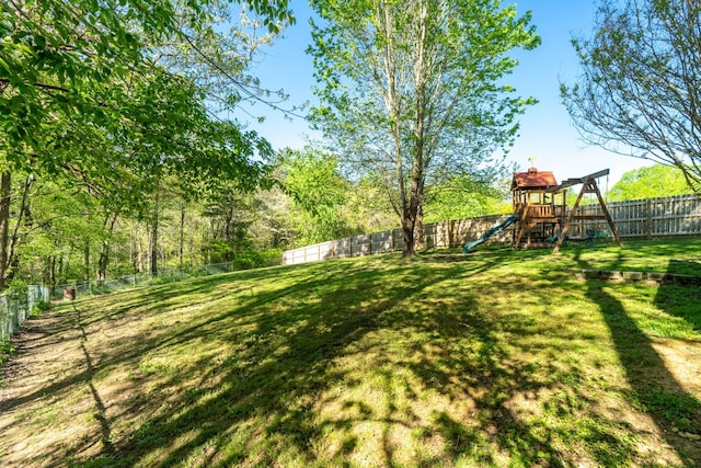 view of yard with a fenced backyard and a playground