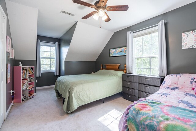 bedroom featuring vaulted ceiling, light colored carpet, baseboards, visible vents, and a ceiling fan
